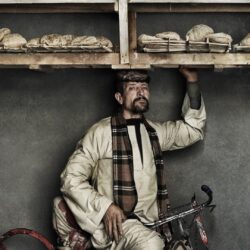 رجل يحمل فوق رأسه صينية خبز على دراجة في مصر..مصور أزياء شهير يكشف عن عادة فريدة من نوعها حول العالم