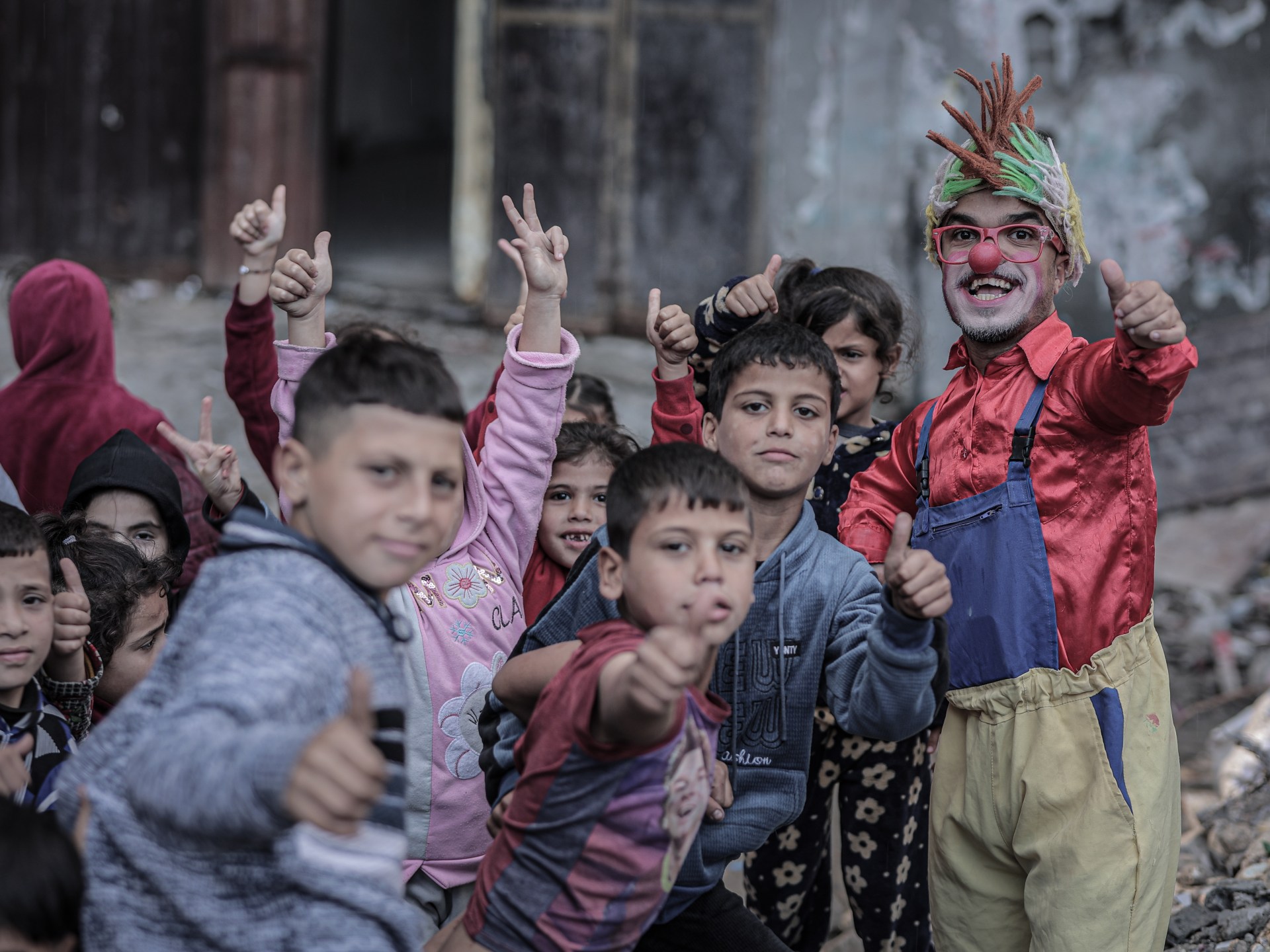 بالصور.. مهرّج مكلوم يرسم الابتسامة على وجوه أطفال غزة